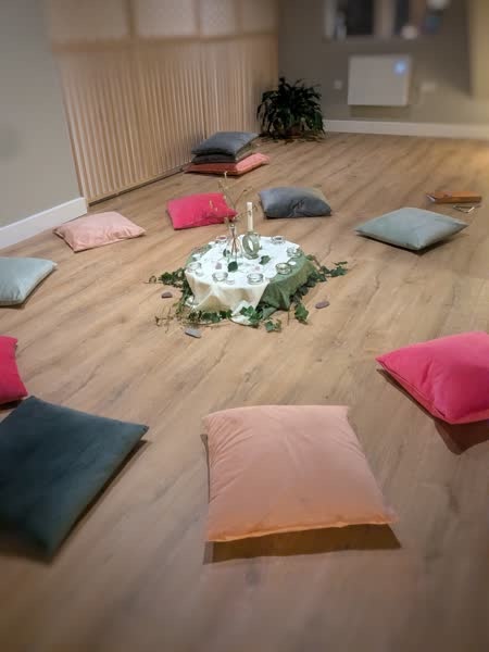 Floor cushions arranged around a candlelit centrepiece